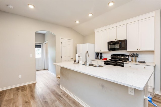 1517 Dorado St, Corpus Christi, TX 78417 - kitchen with black appliances, arched walkways, an island with sink, decorative backsplash, and light wood-type flooring