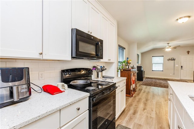 1517 Dorado St, Corpus Christi, TX 78417 - kitchen with black appliances, light wood-style floors, white cabinetry, decorative backsplash, and lofted ceiling