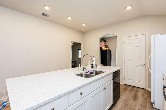 1517 Dorado St, Corpus Christi, TX 78417 - kitchen featuring black appliances, arched walkways, white cabinets, light wood-style floors, and a kitchen island with sink
