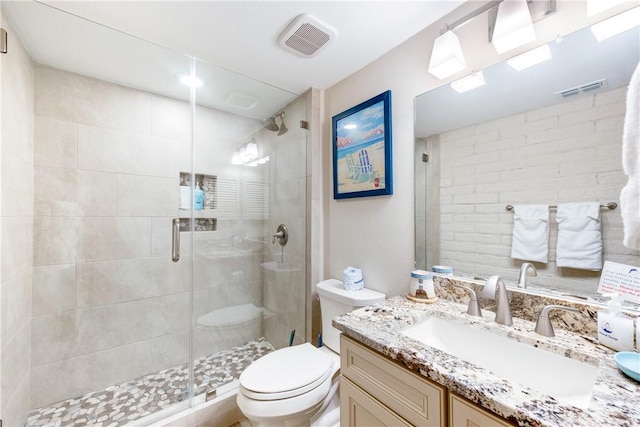 bathroom featuring an enclosed shower, vanity, and toilet