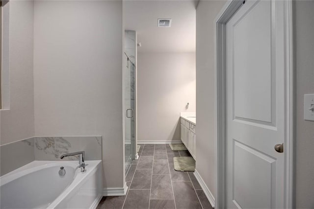 bathroom featuring independent shower and bath, vanity, and tile patterned floors