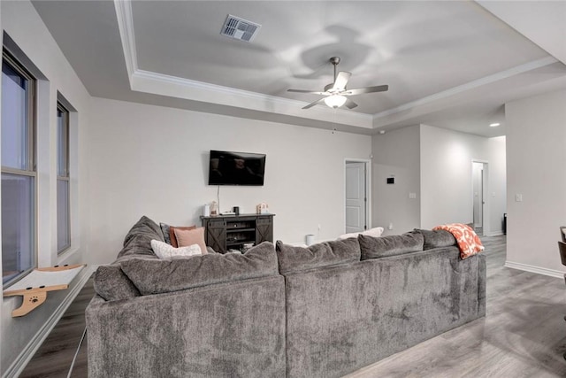 living room with crown molding, dark hardwood / wood-style floors, and a tray ceiling