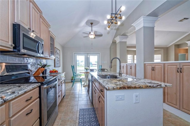 7410 Lake Micala Dr, Corpus Christi, TX 78413 - kitchen with stainless steel appliances, vaulted ceiling, light brown cabinetry, a kitchen island with sink, and plenty of natural light
