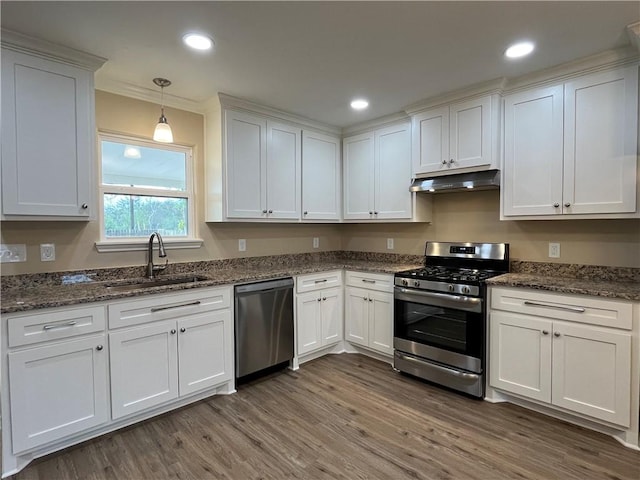 kitchen featuring appliances with stainless steel finishes, dark wood-type flooring, sink, pendant lighting, and white cabinets