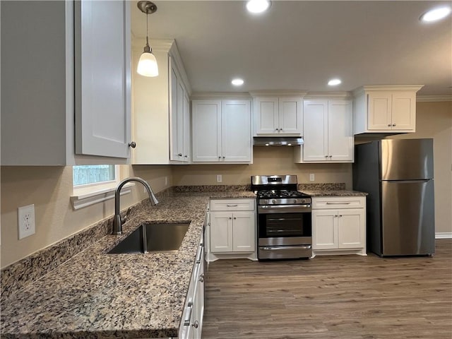 kitchen featuring sink, stainless steel appliances, pendant lighting, stone countertops, and white cabinets