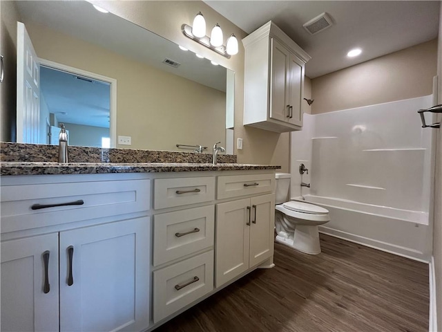 full bathroom featuring vanity, wood-type flooring, bathtub / shower combination, and toilet