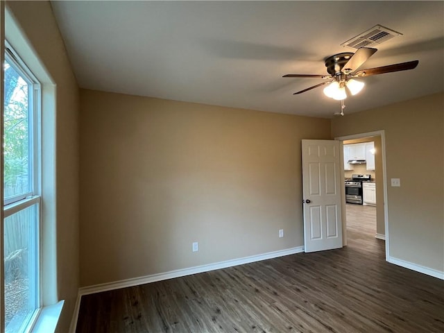 unfurnished room featuring ceiling fan and dark wood-type flooring