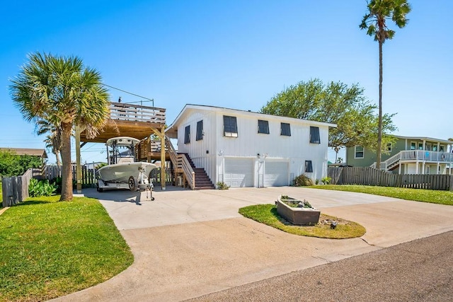 view of front of home featuring concrete driveway, stairway, an attached garage, fence, and a front yard