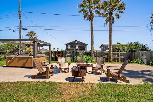 view of patio with an outdoor fire pit, fence private yard, and a hot tub