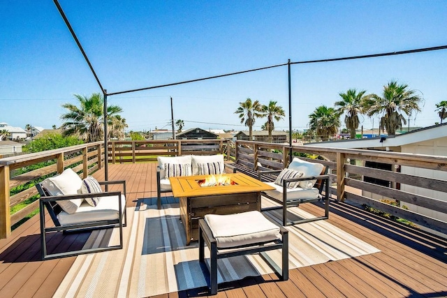 wooden terrace featuring an outdoor living space with a fire pit