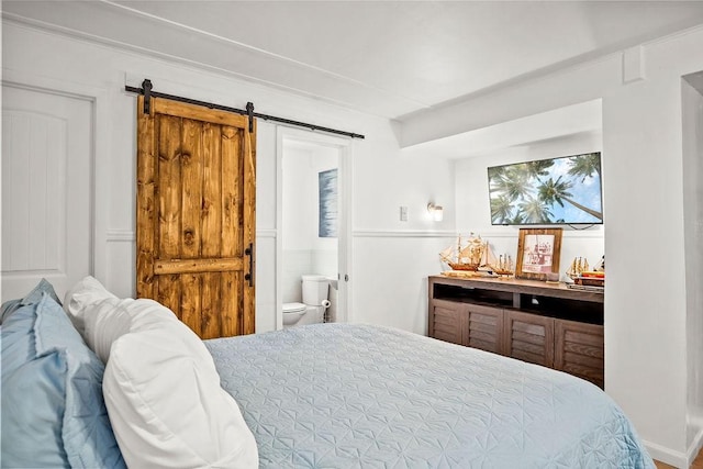 bedroom with ensuite bath and a barn door