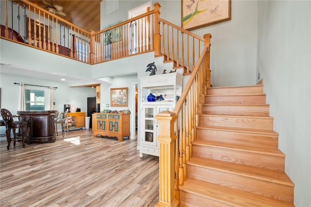 stairs featuring hardwood / wood-style floors and a towering ceiling