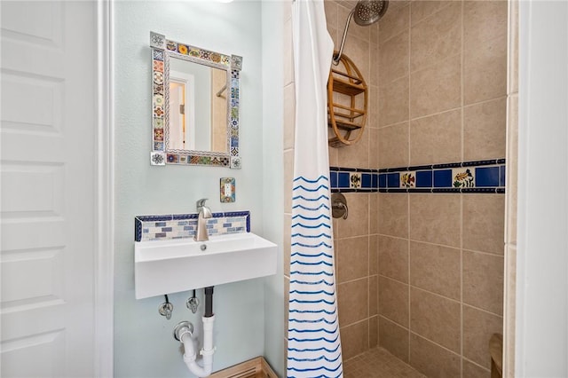 bathroom with a shower with curtain, sink, and backsplash