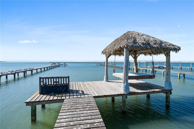 view of dock with a gazebo and a water view