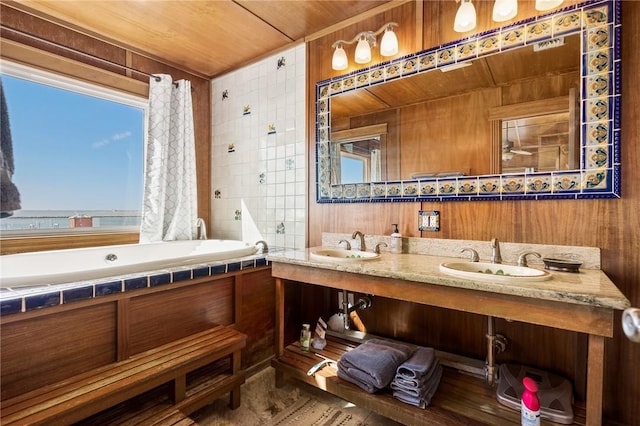 bathroom with vanity, wood walls, wood ceiling, and a bath