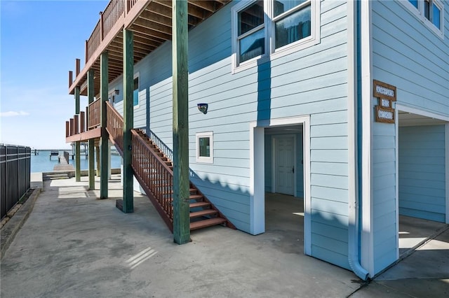 view of side of property featuring a patio and a water view