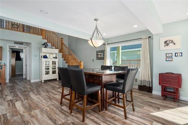 dining area with hardwood / wood-style floors and beam ceiling