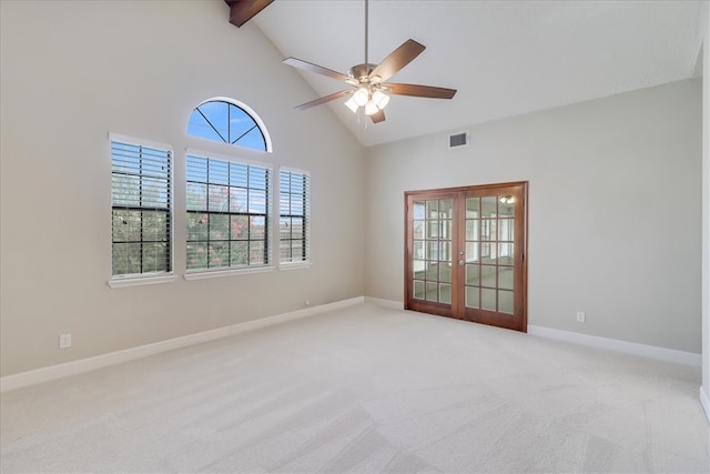 empty room with high vaulted ceiling, beamed ceiling, light carpet, and ceiling fan