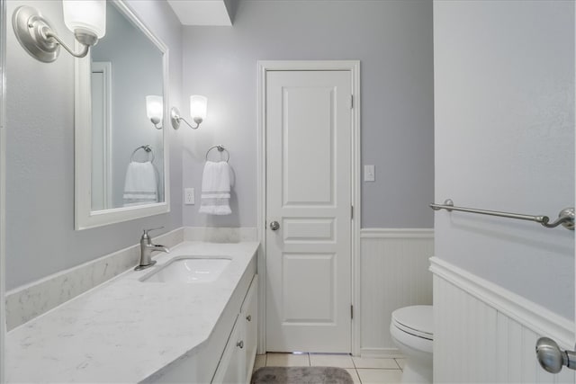 bathroom with toilet, vanity, and tile patterned floors