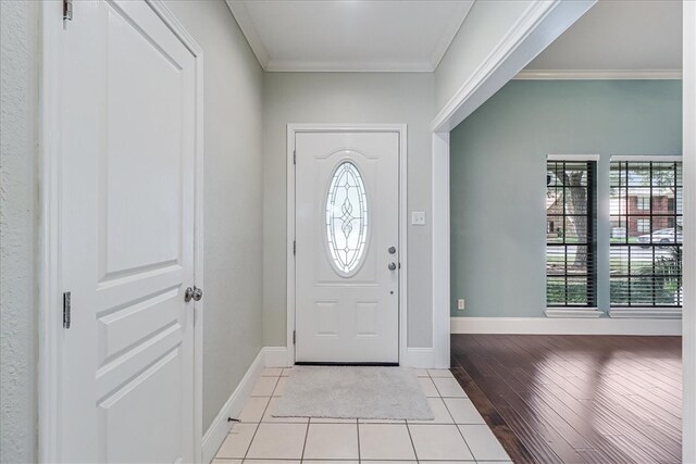 foyer entrance with light hardwood / wood-style flooring and crown molding