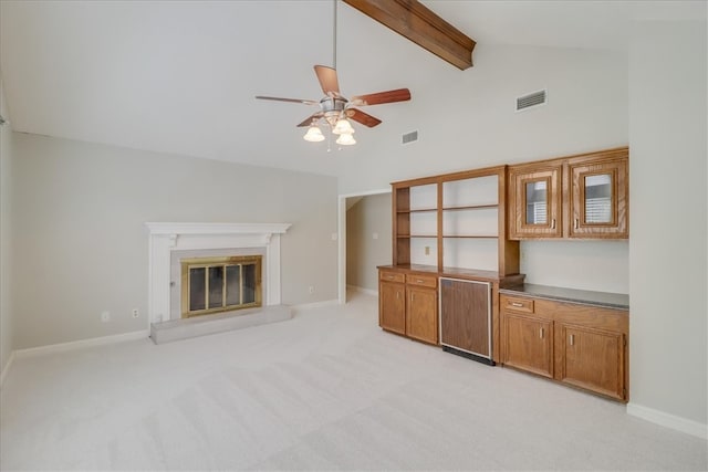 unfurnished living room with high vaulted ceiling, beamed ceiling, light colored carpet, and ceiling fan