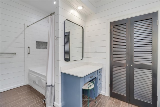 bathroom with wood walls and shower / bath combo