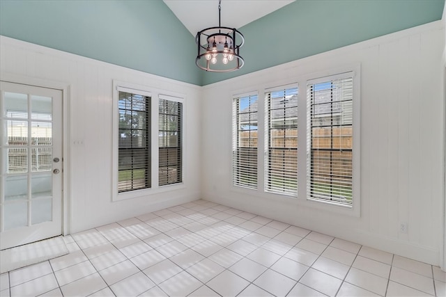 interior space with lofted ceiling, light tile patterned floors, and an inviting chandelier