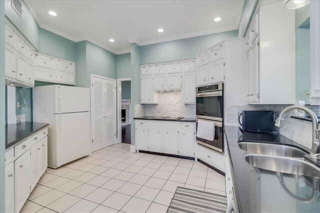 kitchen with white cabinets, stainless steel double oven, and white refrigerator