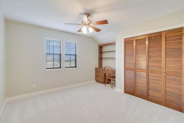 unfurnished bedroom with light carpet, ceiling fan, vaulted ceiling, and a closet