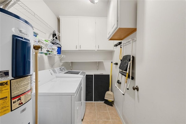 washroom featuring cabinets, light tile patterned flooring, washer and dryer, and electric water heater