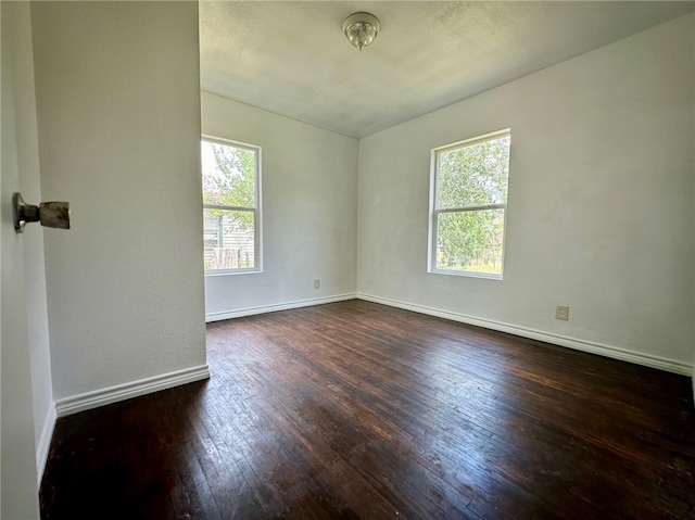 unfurnished room with dark wood-type flooring