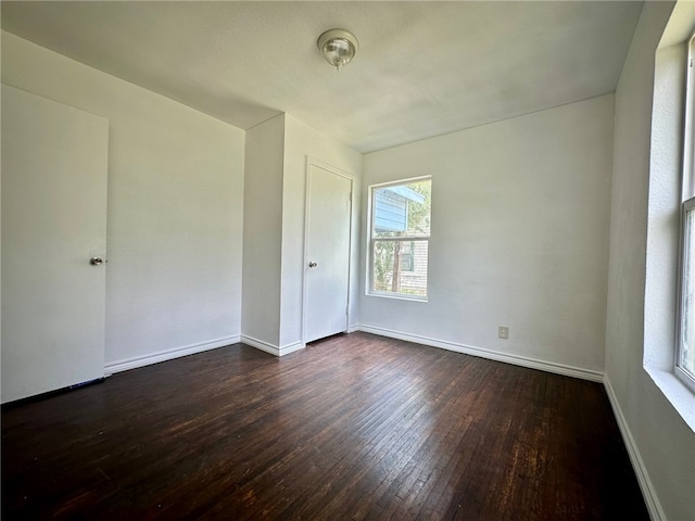 unfurnished room with dark hardwood / wood-style floors