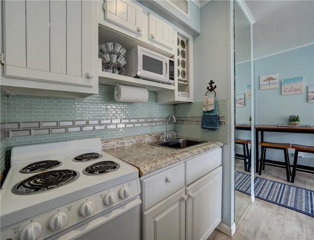 3938 Surfside Blvd Unit 3124, Corpus Christi, TX 78402 - kitchen featuring white appliances, a sink, backsplash, light wood-type flooring, and white cabinets