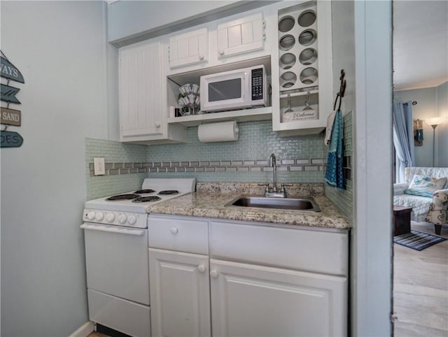 3938 Surfside Blvd Unit 3124, Corpus Christi, TX 78402 - kitchen with white appliances, a sink, tasteful backsplash, white cabinets, and light stone counters