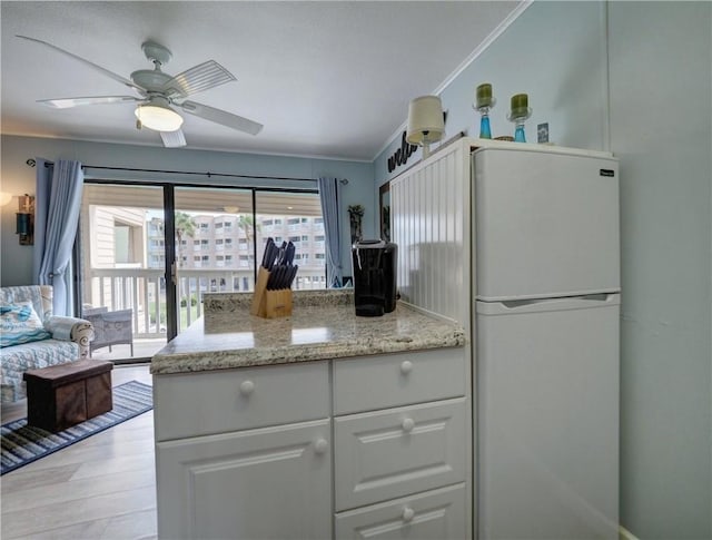 3938 Surfside Blvd Unit 3124, Corpus Christi, TX 78402 - kitchen featuring freestanding refrigerator, crown molding, a ceiling fan, white cabinetry, and light stone countertops