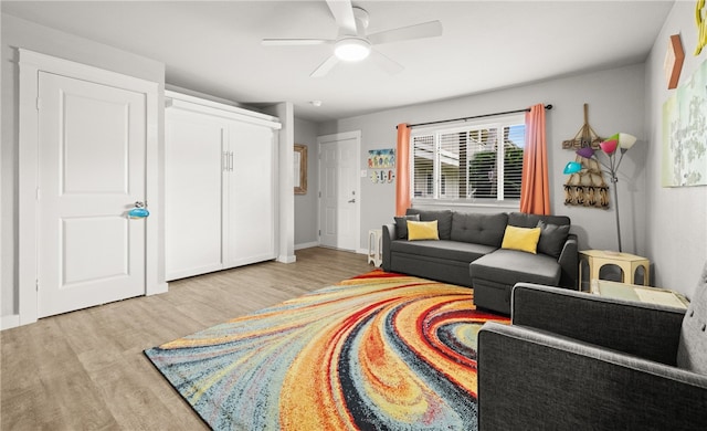 living room with ceiling fan and light hardwood / wood-style flooring