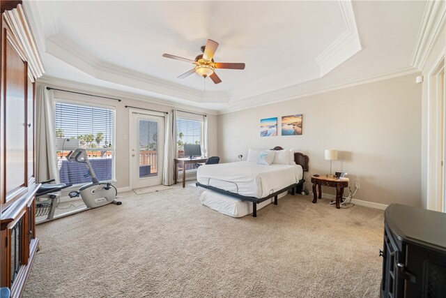 carpeted bedroom featuring access to exterior, ornamental molding, ceiling fan, and a tray ceiling