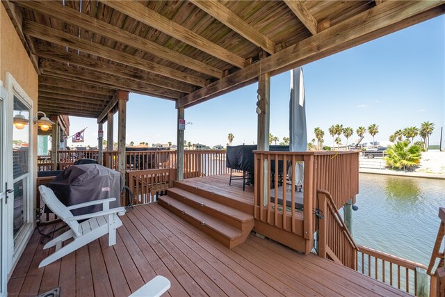 wooden terrace with a grill and a water view