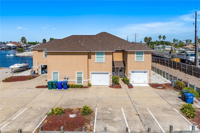 back of house featuring a garage and a water view