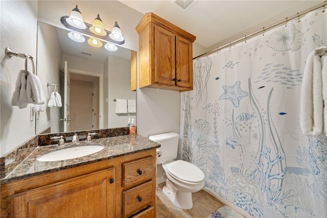 bathroom featuring tile patterned flooring, vanity, and toilet