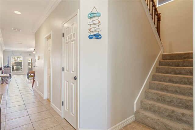 staircase with tile patterned floors and ornamental molding