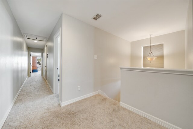 hall with light colored carpet