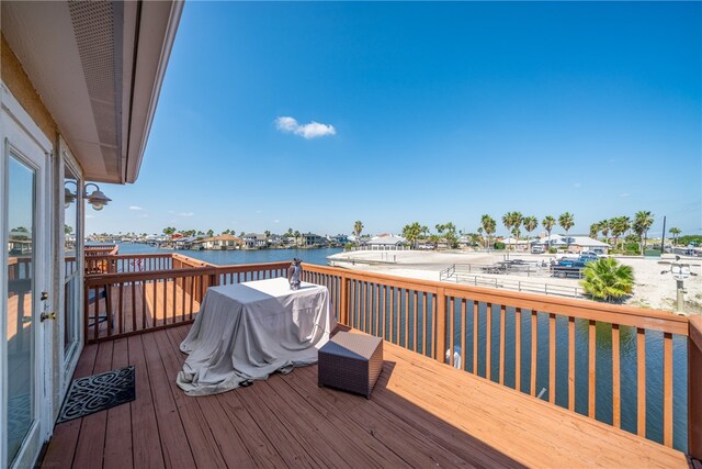 wooden deck with a water view and a grill