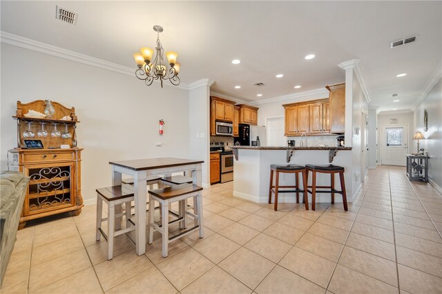 dining room with ornamental molding, light tile patterned floors, and an inviting chandelier