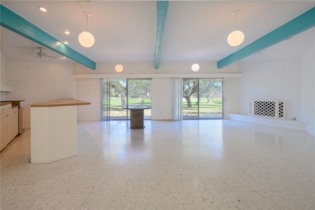 unfurnished living room with ceiling fan and beam ceiling