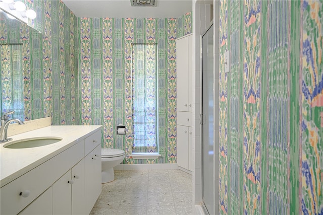 bathroom with toilet, vanity, and an enclosed shower