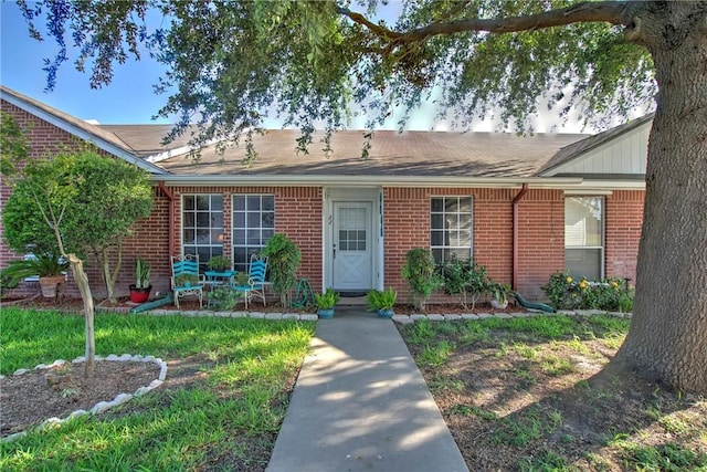 13656 Teague Ln Unit 22, Corpus Christi, TX 78410 - view of front facade featuring brick siding, roof with shingles, and a patio area