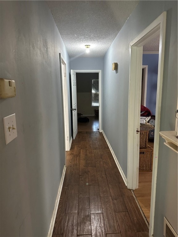 hall featuring dark hardwood / wood-style flooring and a textured ceiling