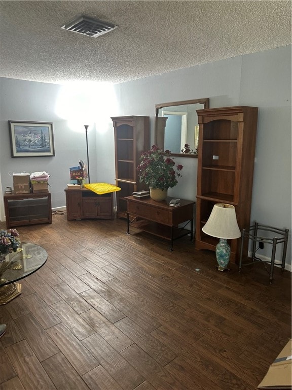 sitting room featuring dark hardwood / wood-style flooring and a textured ceiling