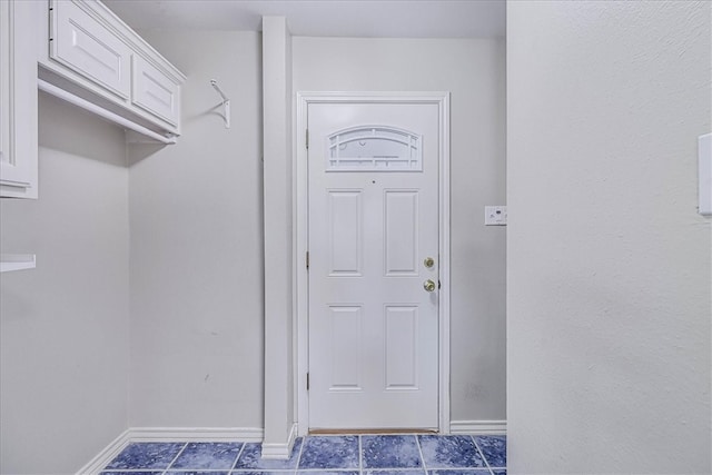 entryway with dark tile patterned flooring